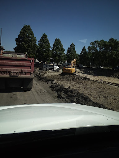 Road construction scene with heavy machinery and trucks.
