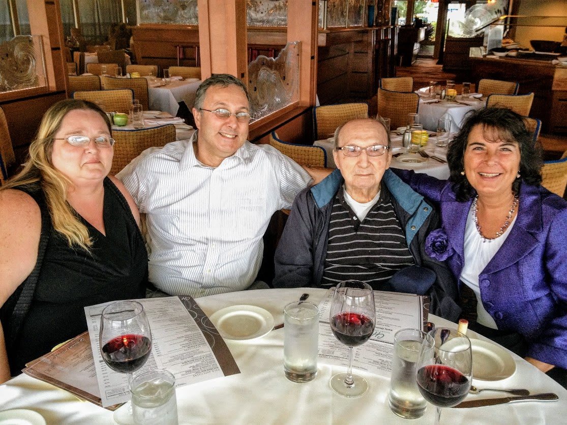 A group of four people enjoying a meal at a restaurant.