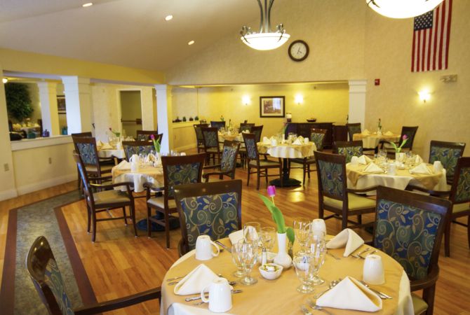 An elegant dining room with tables set for a formal meal.