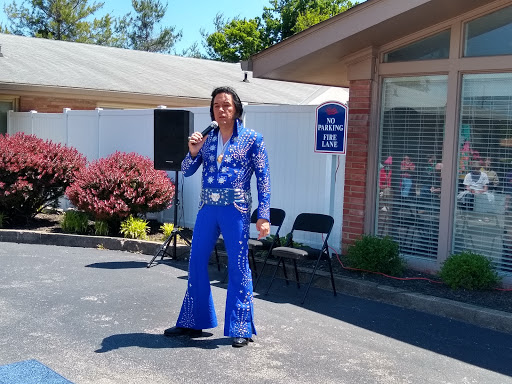 An entertainer performing in a striking blue suit, capturing the essence of a classic rock and roll icon.