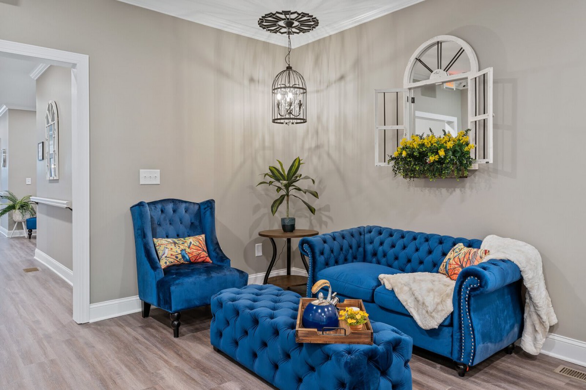 A stylish living room featuring blue tufted furniture and elegant decor accents.