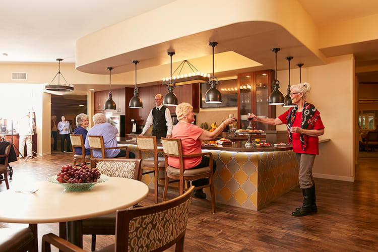 A bustling restaurant scene with people enjoying a buffet setup.