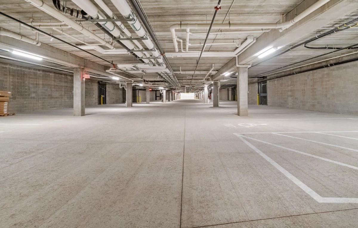 Empty underground parking garage with concrete walls and pillars.