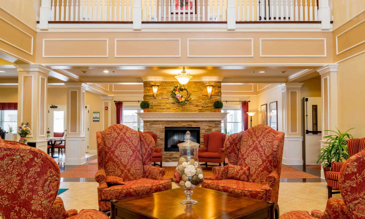 A cozy and elegant living room featuring a central fireplace surrounded by comfortable chairs.