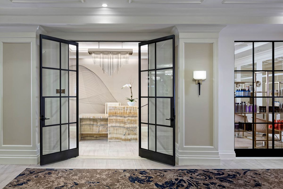 A luxurious reception area with glass double doors and elegant decor.