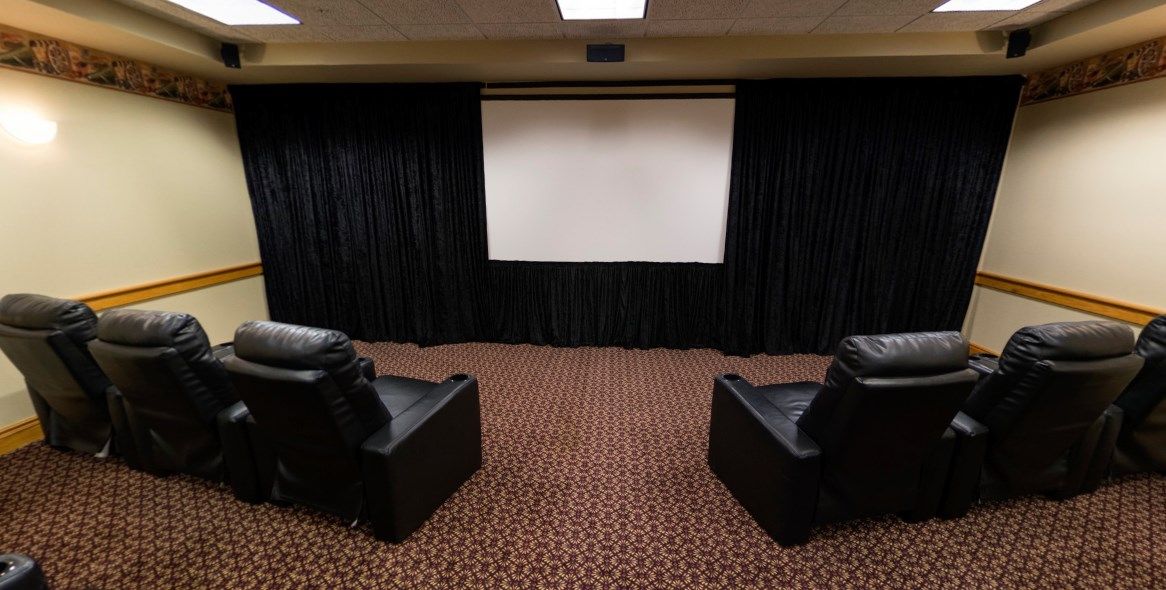 A cozy home theater setup with a large projection screen and comfortable seating.
