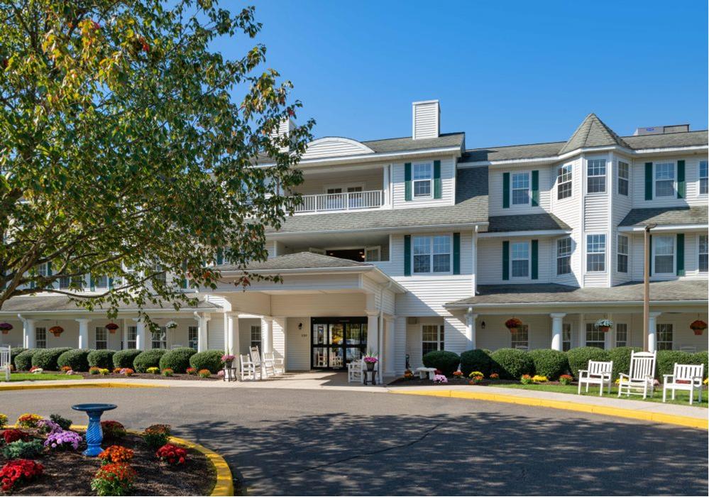 A sunny day view of a residential building with landscaped surroundings.