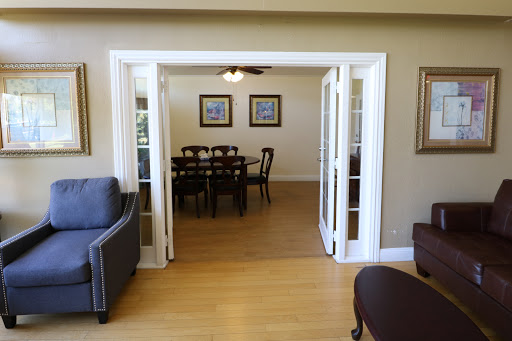 A view from the living room into the dining area, showcasing elegant furnishings and natural light.