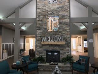 A welcoming lobby area featuring a large stone fireplace and comfortable seating.