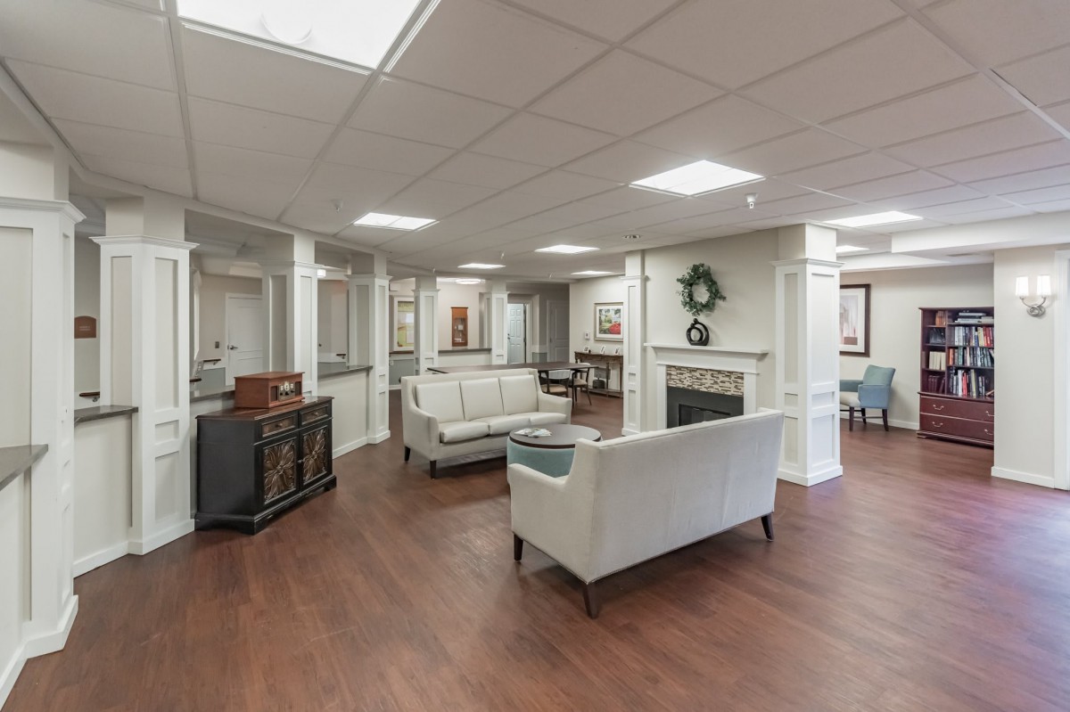 A modern lobby with white sofas and wood flooring.