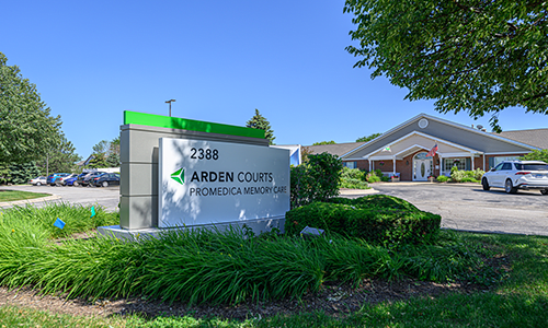 A view of the Arden Courts healthcare facility with a prominent outdoor sign and well-maintained landscaping.