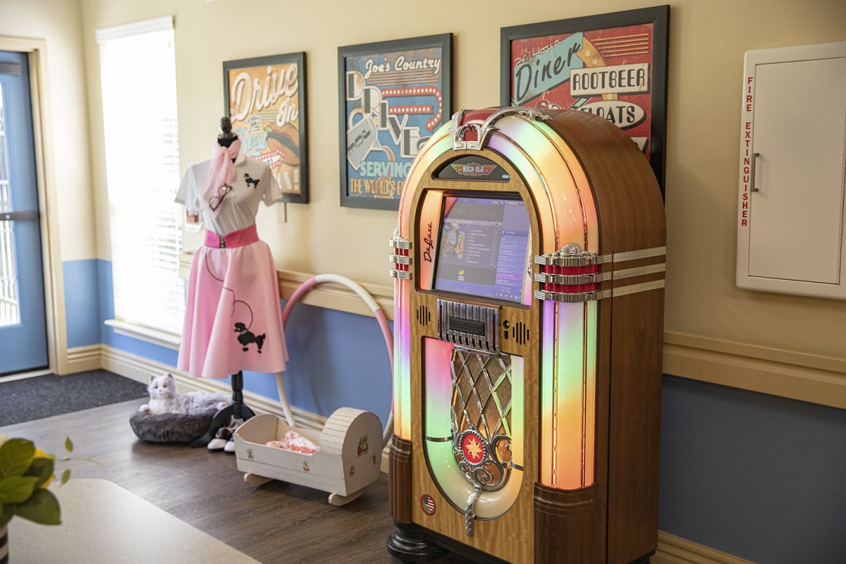 A retro-themed room featuring a vintage jukebox and a display of 1950s attire.