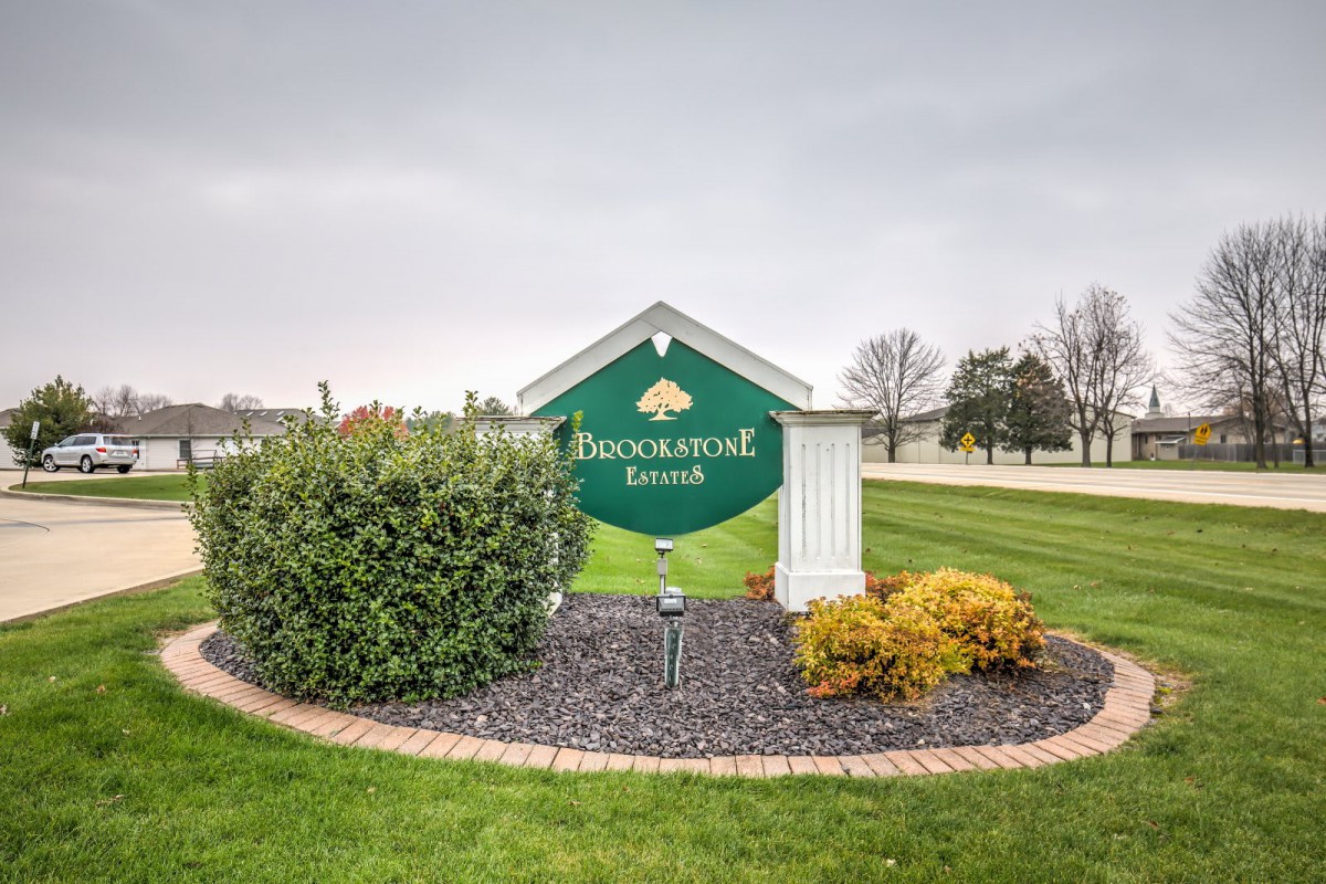 A welcoming sign for Duckwood Ranch surrounded by neatly arranged shrubs and plants.