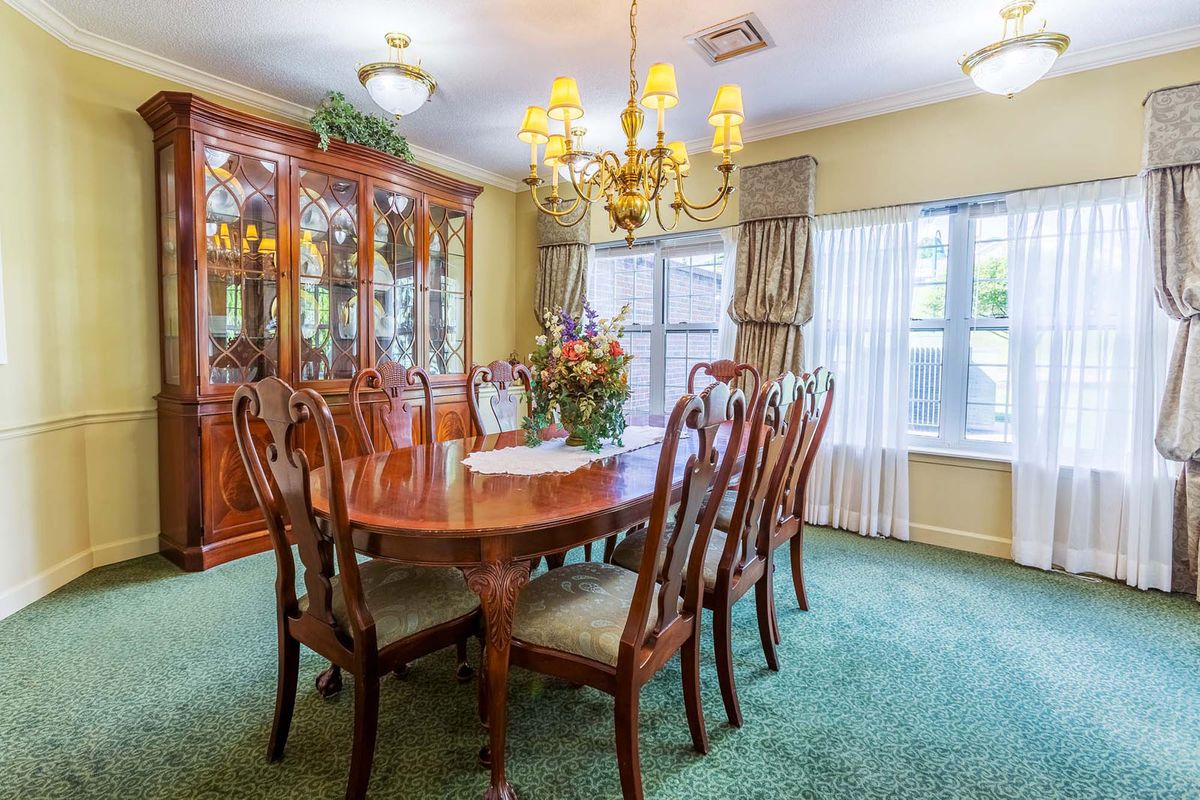 A classic dining room with a wooden table, chairs, and a chandelier.