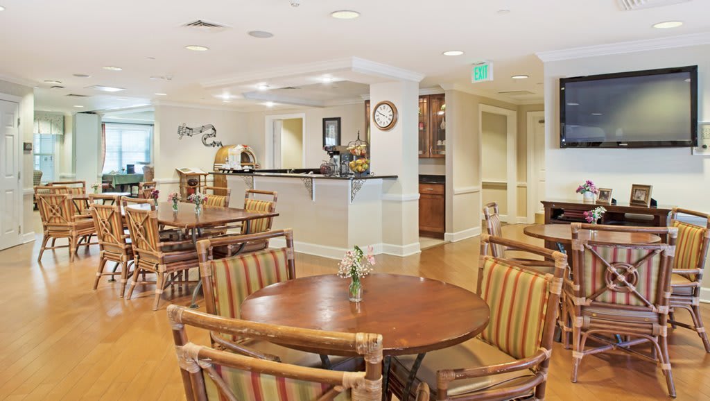 A cozy dining area with wooden tables and chairs, featuring a welcoming atmosphere.