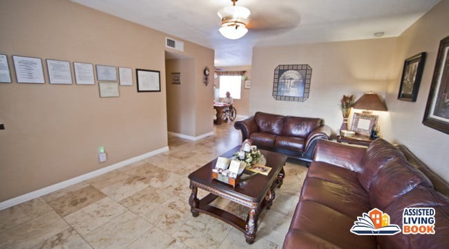 A cozy living room with leather sofas, a wooden coffee table, and decorative artwork on beige walls.