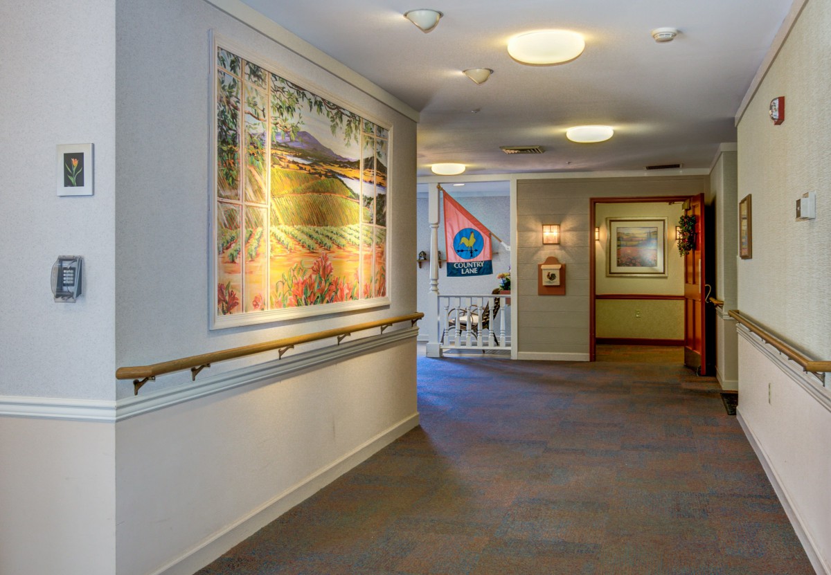 A well-lit hallway featuring artwork on the walls.