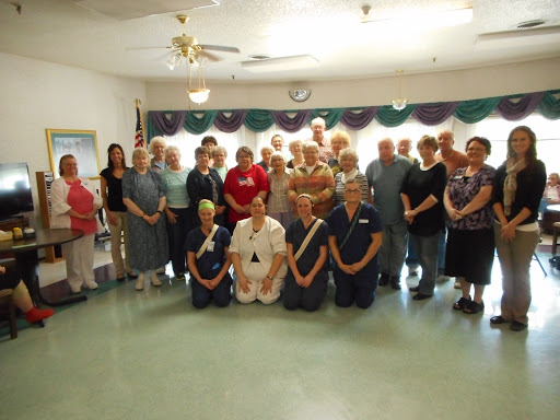 A community gathering with residents and staff, celebrating together.