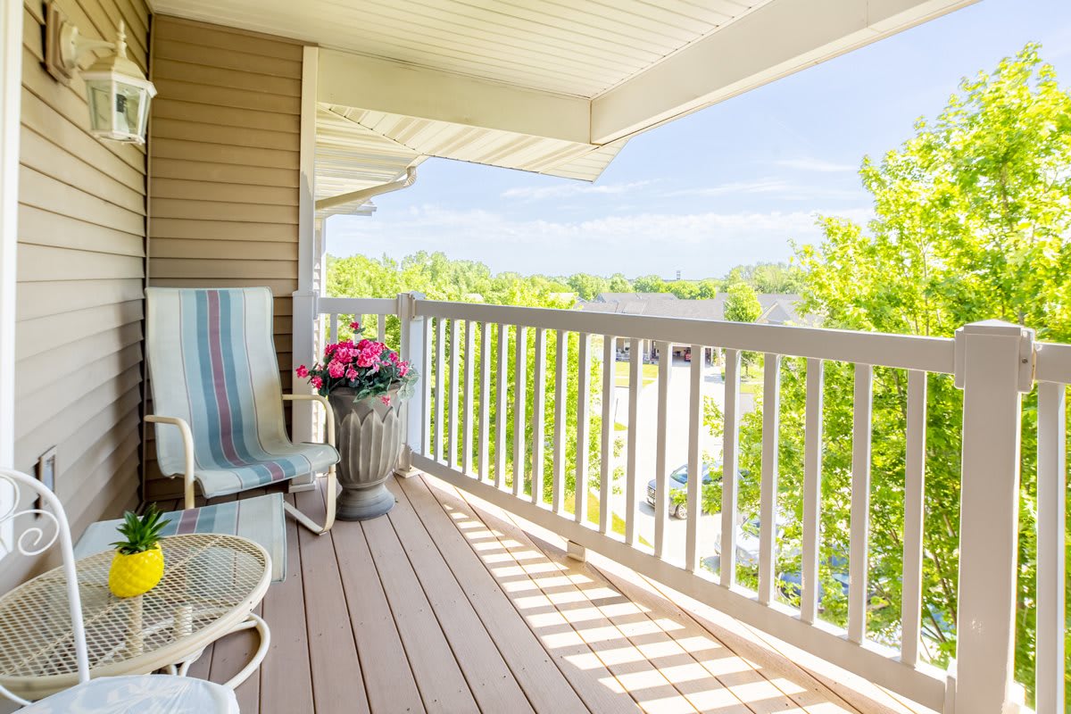 A sunny balcony with comfortable seating and a flower pot, offering a tranquil outdoor space.