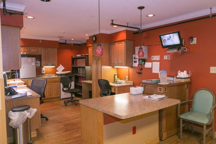 A modern office space with multiple desks and chairs, featuring computer monitors and organized workstations.