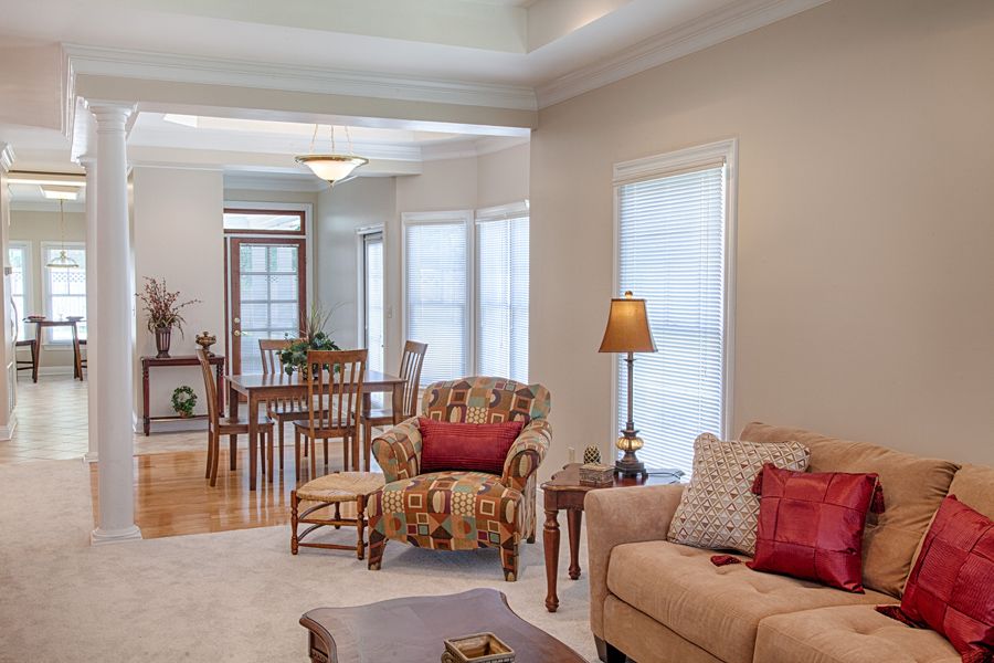 A cozy living room with adjoining dining area featuring comfortable furniture and warm lighting.