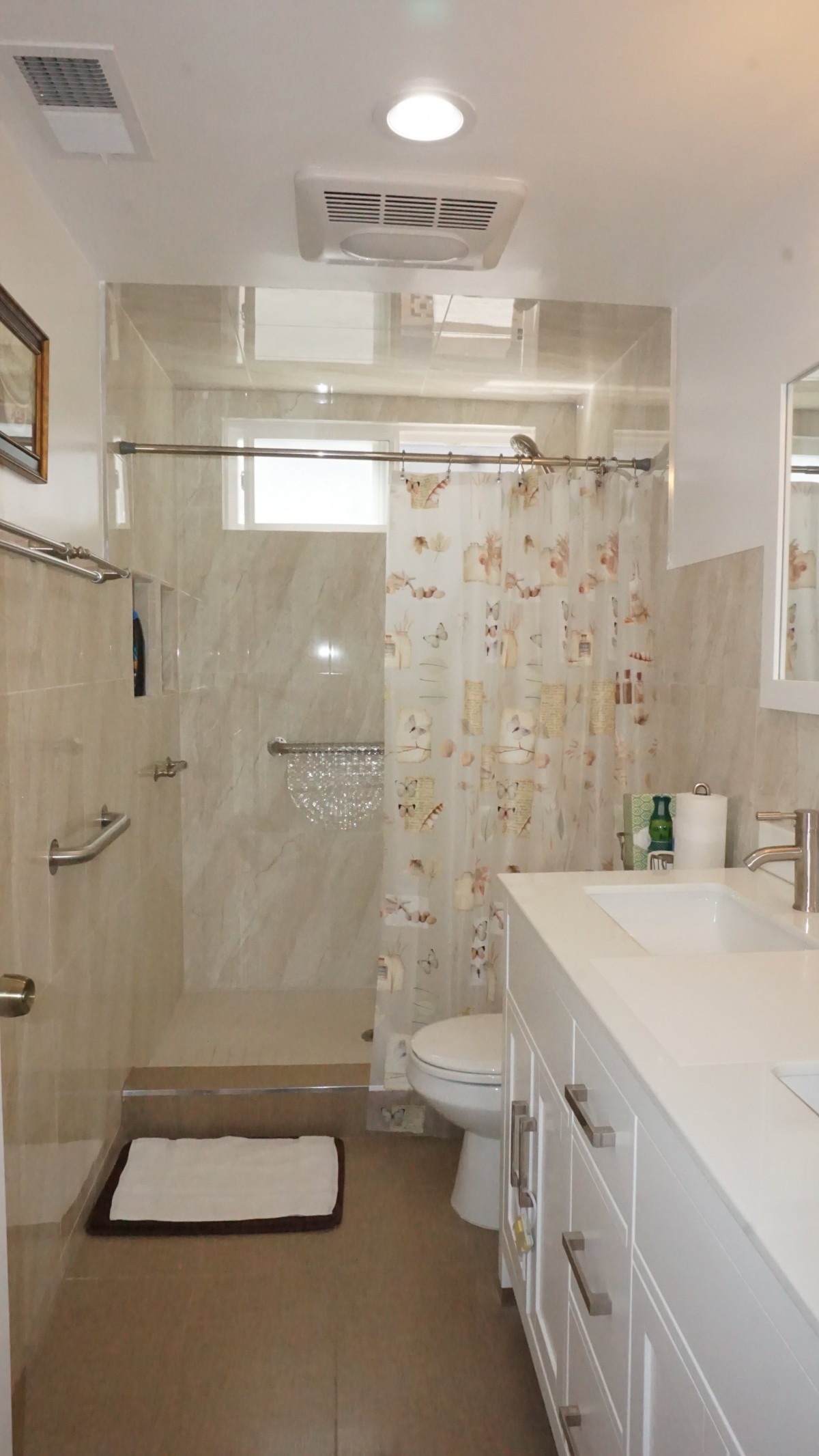 A modern bathroom with a shower area, vanity, and decorative shower curtain.