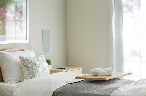 A serene and minimalist bedroom setup featuring neutral tones and modern decor.