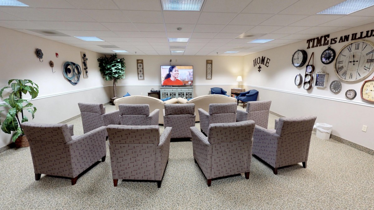A comfortable lounge area with multiple chairs facing a television, ideal for meetings or relaxation.