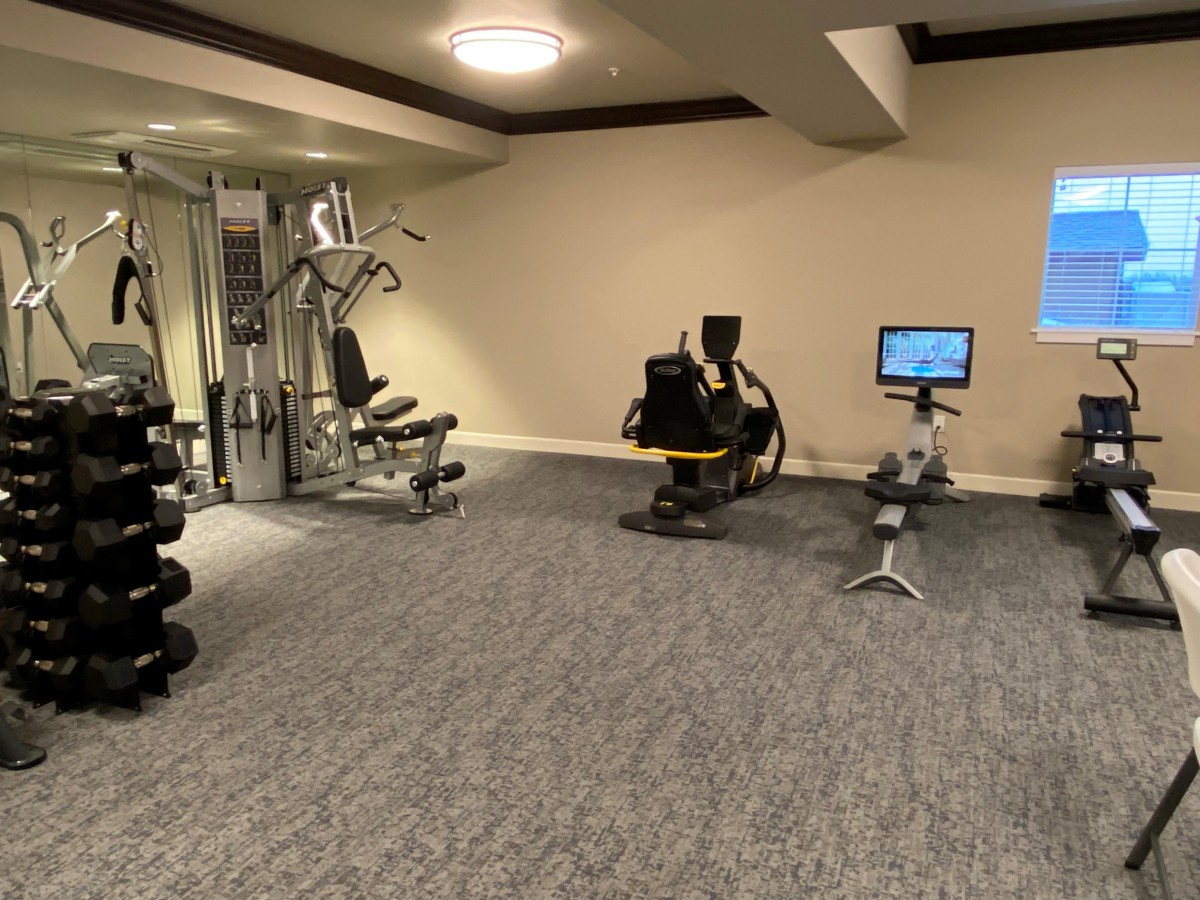 A gym with various exercise equipment including weights and machines.