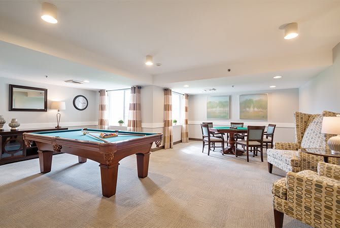 A spacious game room featuring a pool table and additional seating for relaxation.