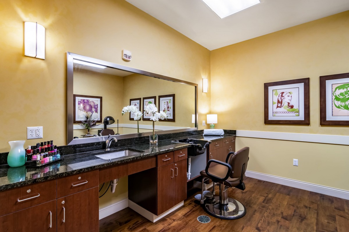 A cozy salon interior with a large mirror, comfortable chair, and elegant decor.