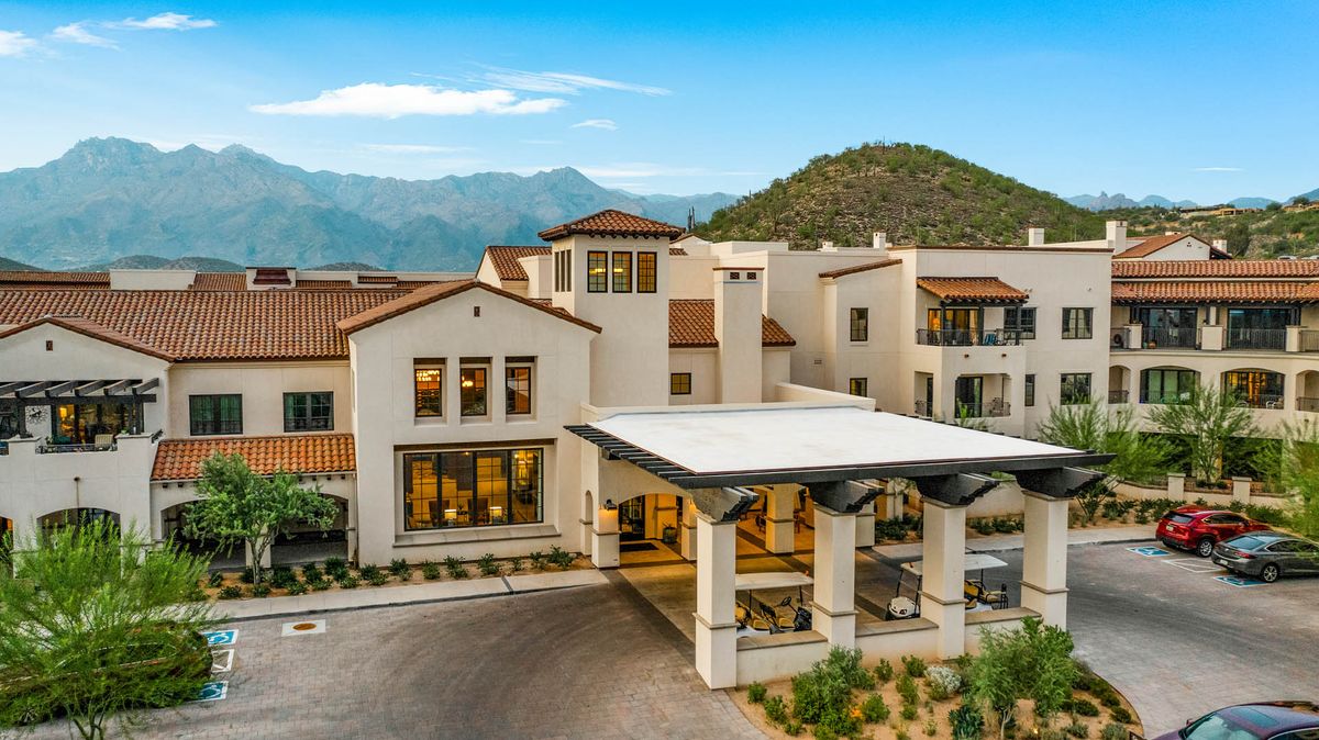 A modern residential building set against a mountainous landscape.