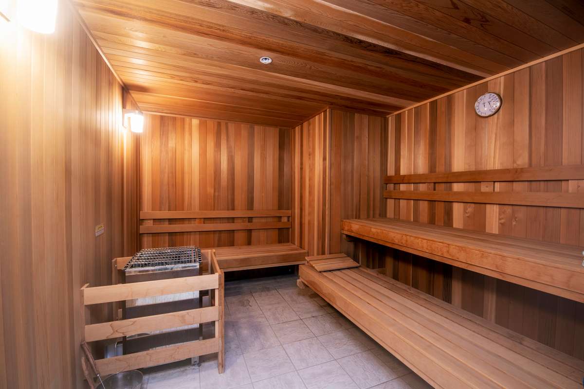 A wooden sauna with benches and a heater for relaxation.