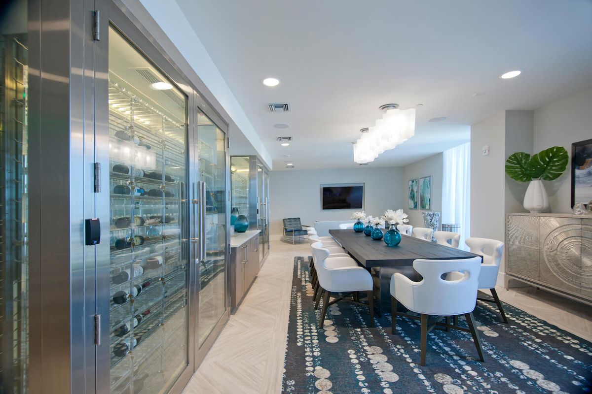 A modern dining room with luxurious interiors and a wine storage display.