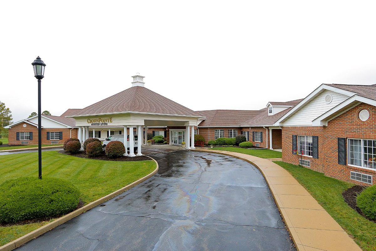 A well-maintained building with a circular driveway and landscaped surroundings.