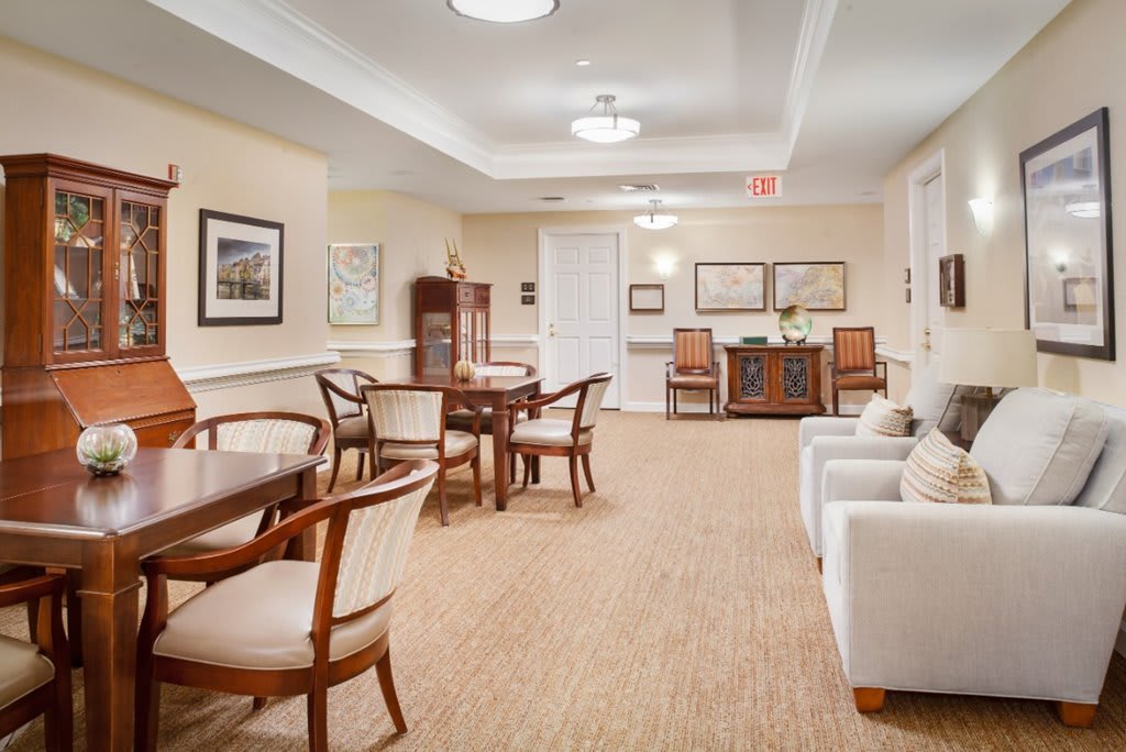 A cozy lounge area with tables and chairs, decorated in neutral tones.