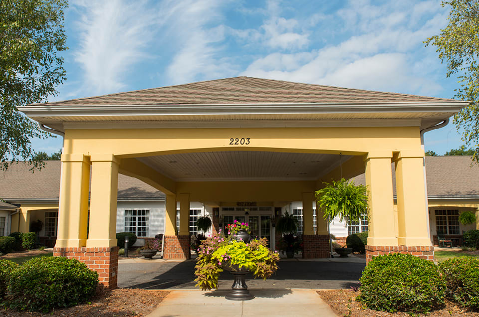 A building entrance with a canopy and surrounding landscaping.