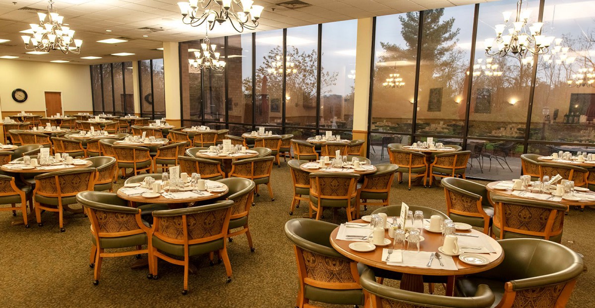 Elegant dining room with neatly arranged tables and large windows.