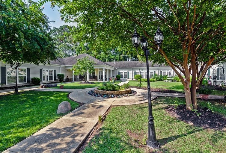 A well-maintained building surrounded by lush greenery and a winding pathway.