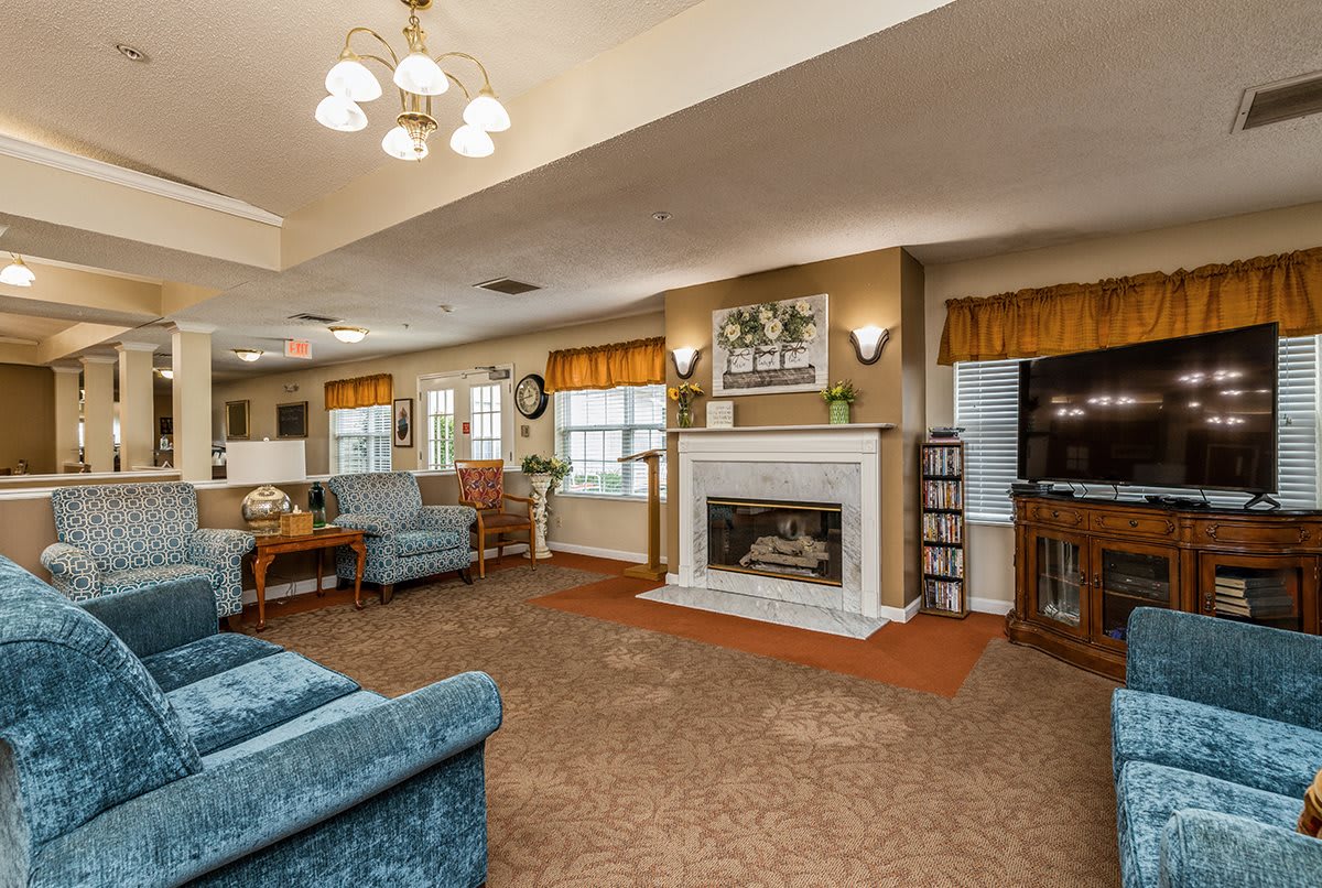 A cozy living room with traditional decor, featuring a fireplace and comfortable seating.