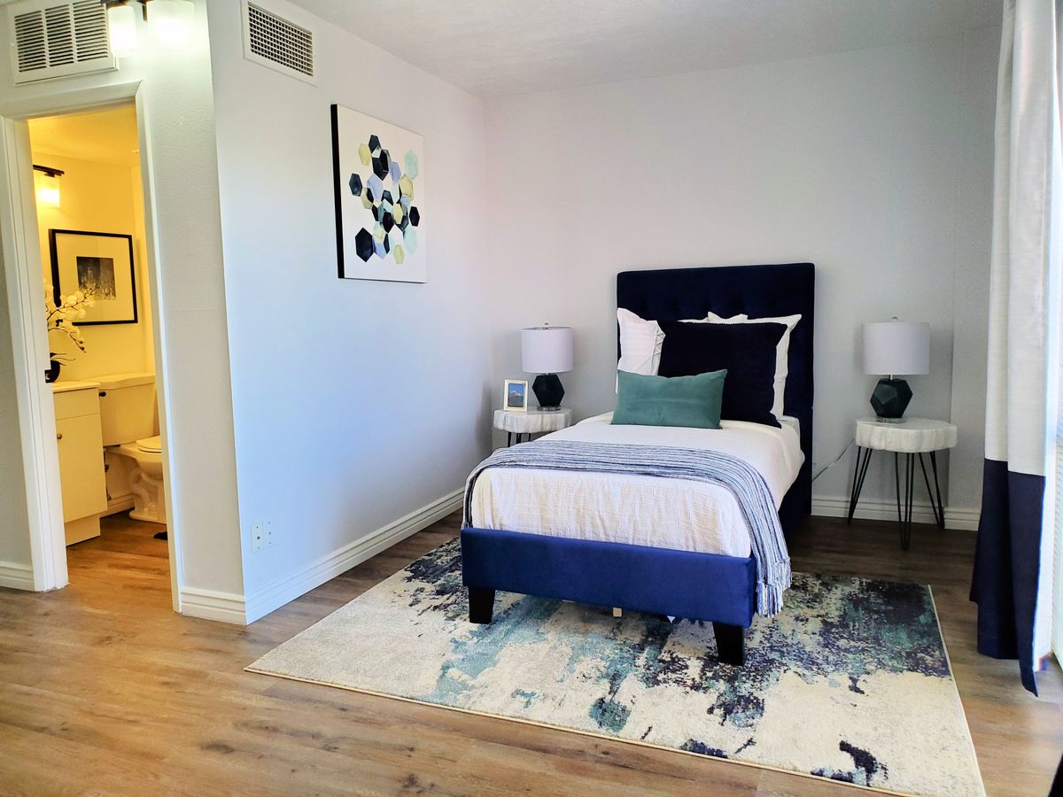 Modern bedroom with a single bed, artwork, and stylish decor.