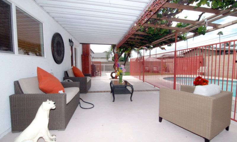 A cozy patio area with comfortable seating overlooking a pool.