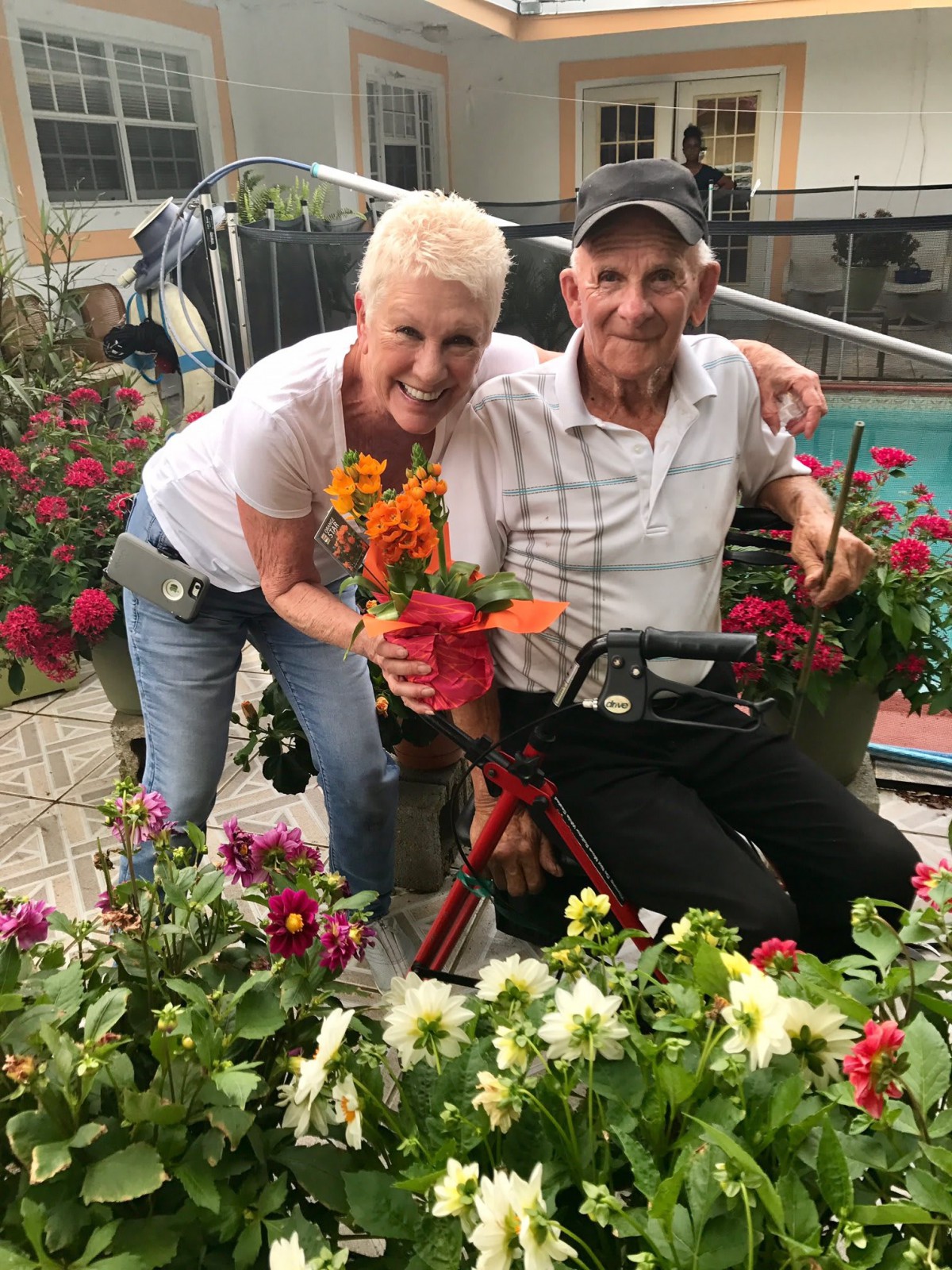 A happy pair surrounded by vibrant flowers in a garden setting.