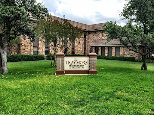 A well-maintained building with lush green grass and a prominent sign.