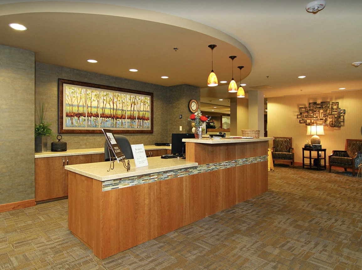 A modern reception area with a curved desk, decorative lighting, and contemporary decor.