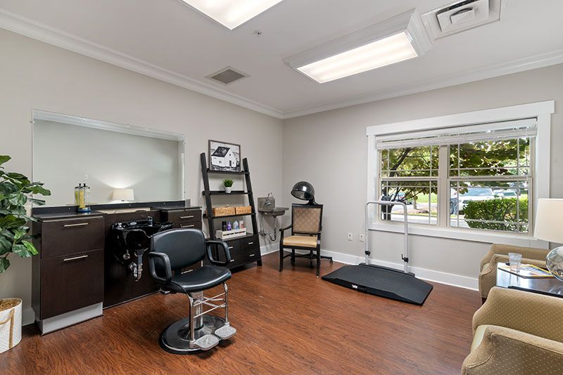 A well-lit hair salon interior featuring a barber chair, mirror, and window.