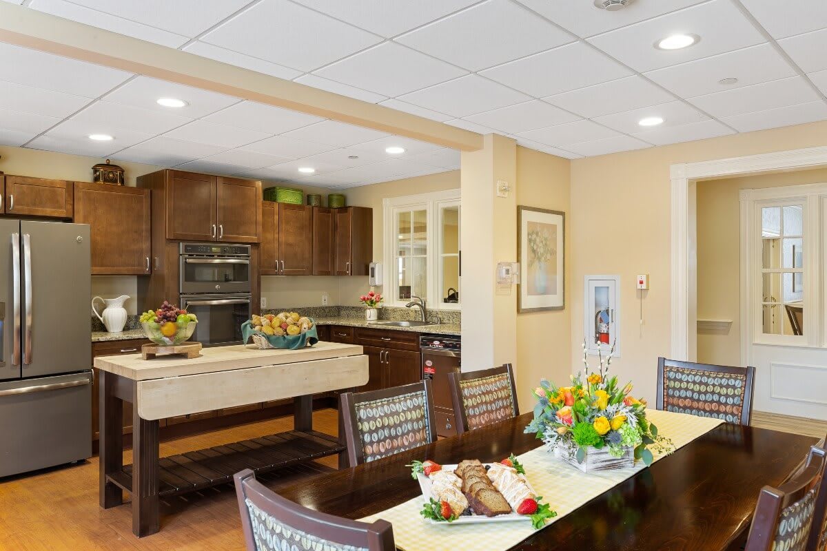 A well-lit kitchen and dining area with modern furnishings and floral decor.