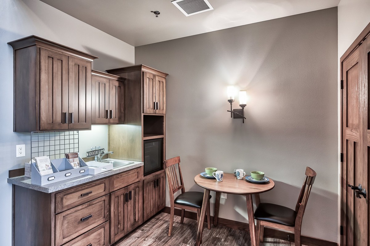 A cozy kitchenette featuring wooden cabinets and a small dining area.