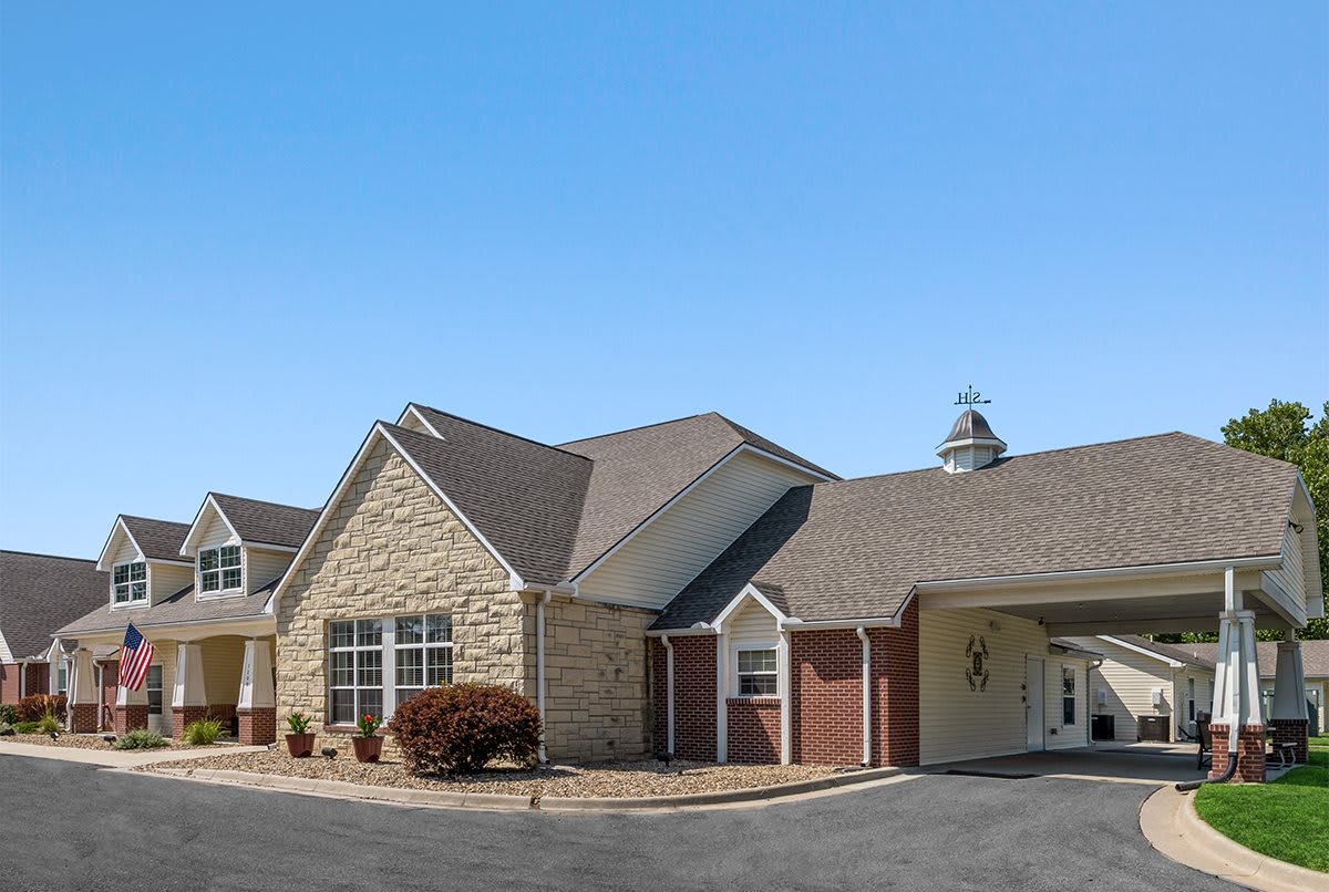 A commercial building with a stone and brick exterior under a clear blue sky.