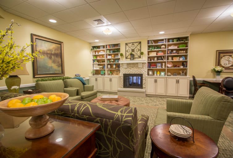 A cozy living room with comfortable seating, bookshelves, and a fireplace.